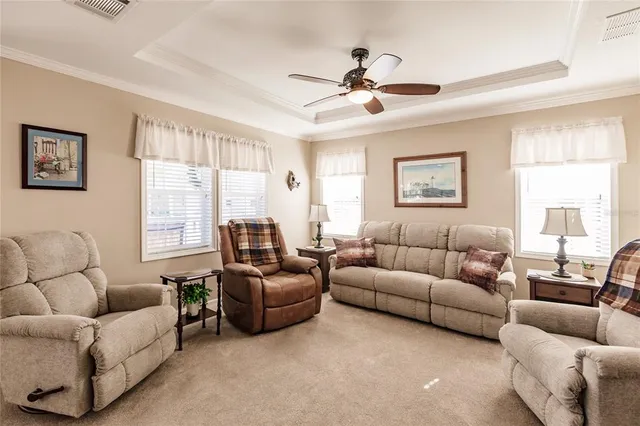 a living room with furniture a ceiling fan a window and a ceiling fan