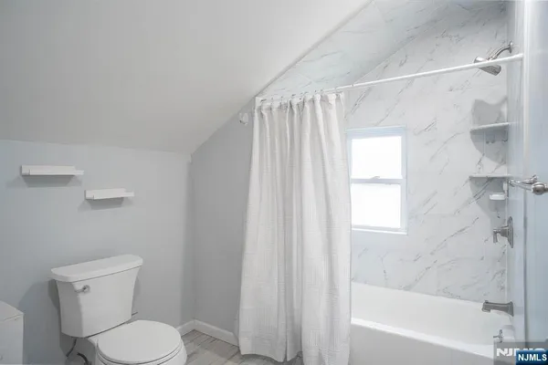 a white toilet sitting next to a bath tub