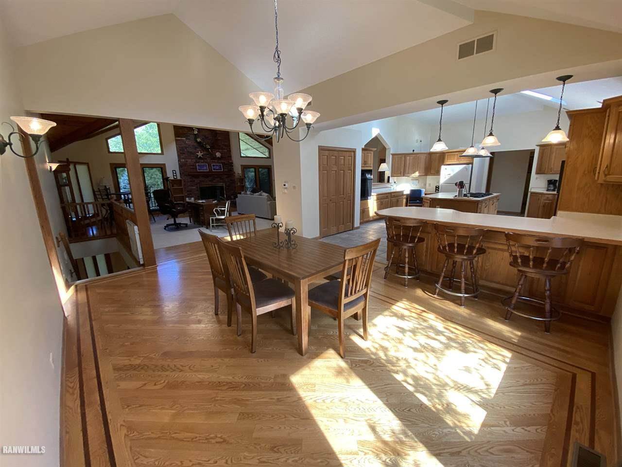 32180 Chambers Grove Road Lanark, IL 61046 - Photo 20 of 44 a view of a dining room with furniture a chandelier and wooden floor