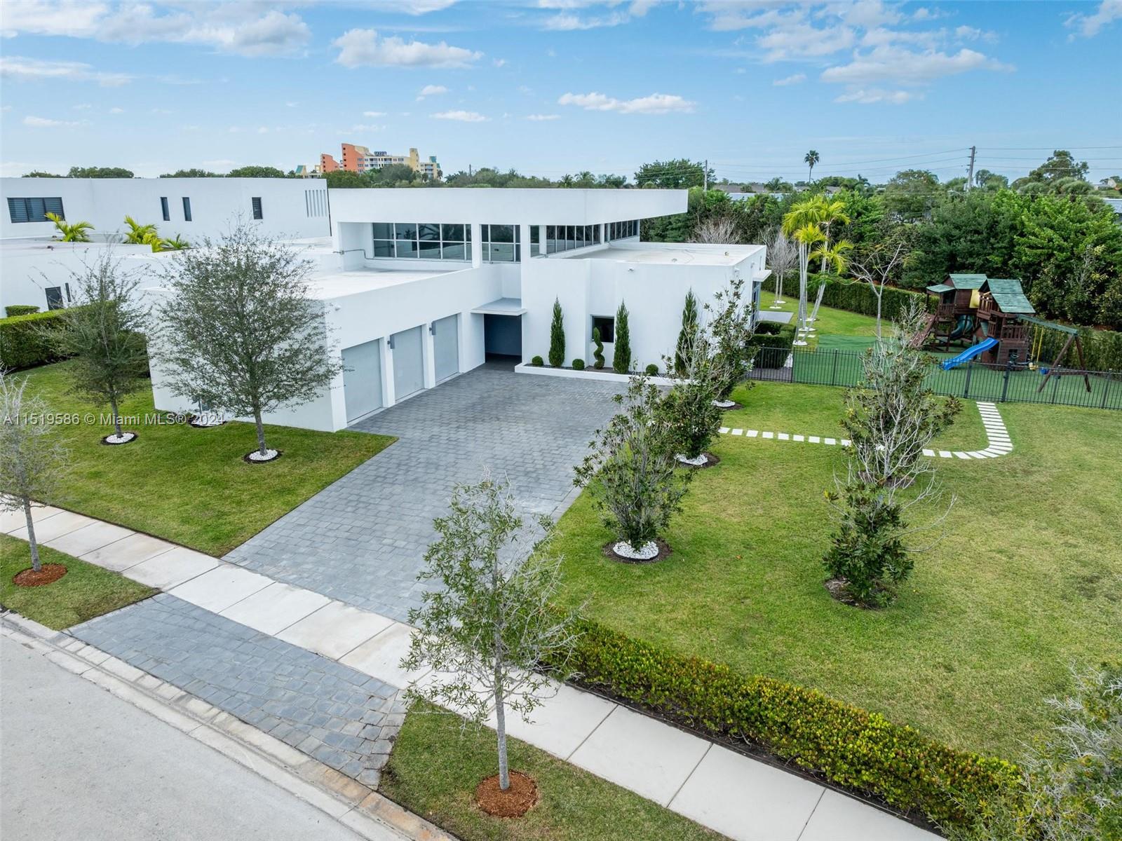 an aerial view of residential houses with outdoor space and trees