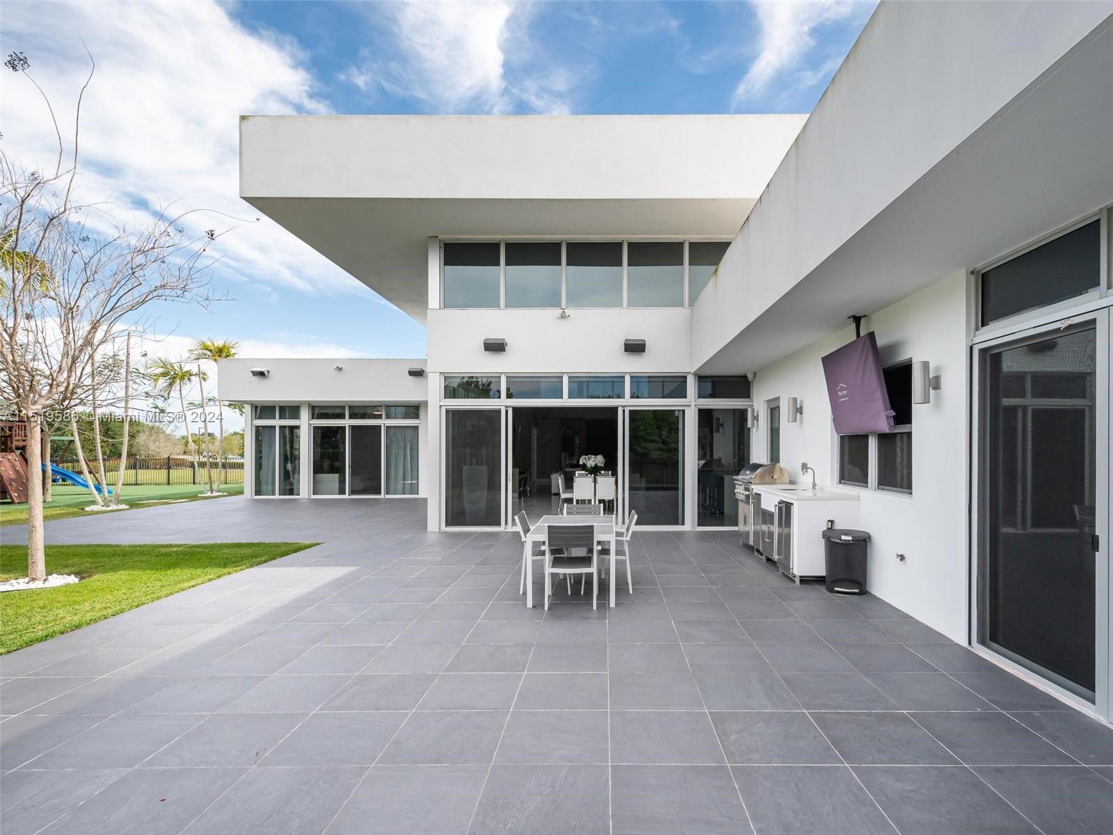 16601 Sunset Way Weston, FL 33326 - Photo 48 of 53 a view of a patio with a table and chairs and potted plants