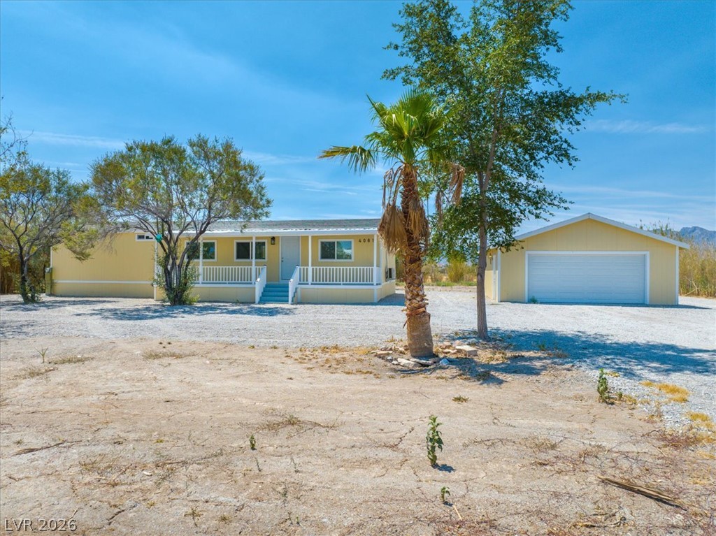 4081 Retread Road Pahrump, NV 89048 - Photo 3 of 98 A cheerful yellow exterior graces this desert oasis home, complete with an inviting front porch and detached garage.