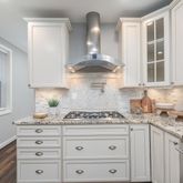 a kitchen with granite countertop a stove cabinets and window