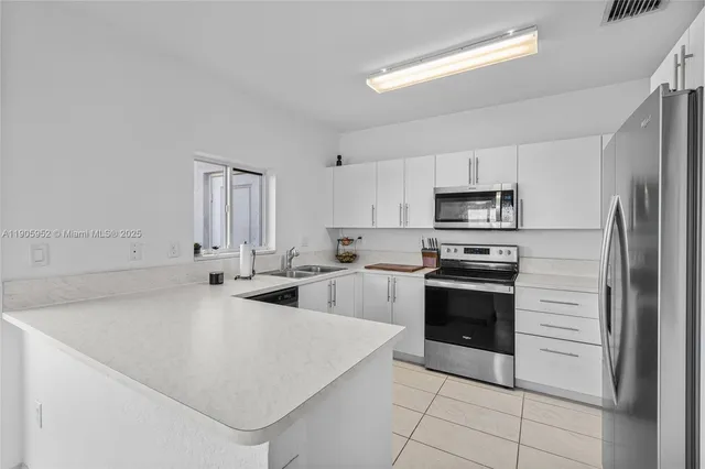 a kitchen with stainless steel appliances a refrigerator sink and stove