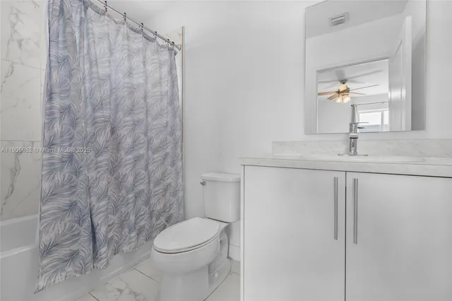 a bathroom with a granite countertop toilet and a sink