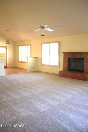 an empty room with a fireplace and windows