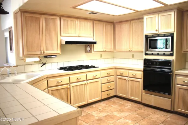 a kitchen with stainless steel appliances granite countertop a stove sink and cabinets