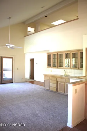 a view of a kitchen with a sink and dishwasher a refrigerator with white cabinets