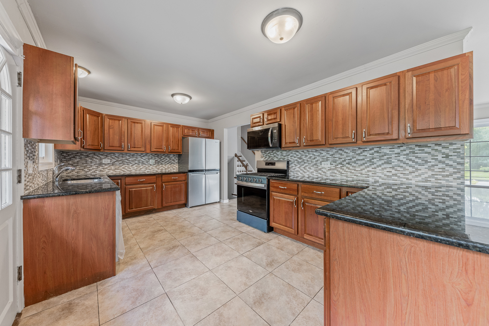 303 Springfield Street Park Forest, IL 60466 - Photo 2 of 16 a kitchen with stainless steel appliances granite countertop a stove sink and cabinets