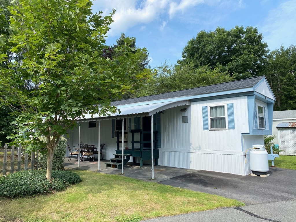 a view of house with backyard outdoor seating and trees