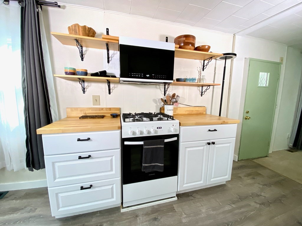 42 Adams Road, Unit 25 Greenfield, MA 01301 - Photo 16 of 37 a kitchen with stainless steel appliances a stove and a flat screen tv