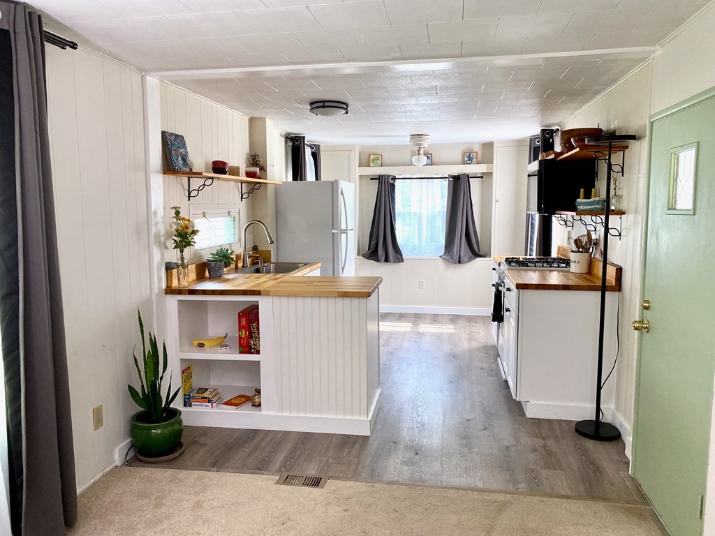 42 Adams Road, Unit 25 Greenfield, MA 01301 - Photo 23 of 37 a living room with kitchen island furniture a kitchen view and a refrigerator