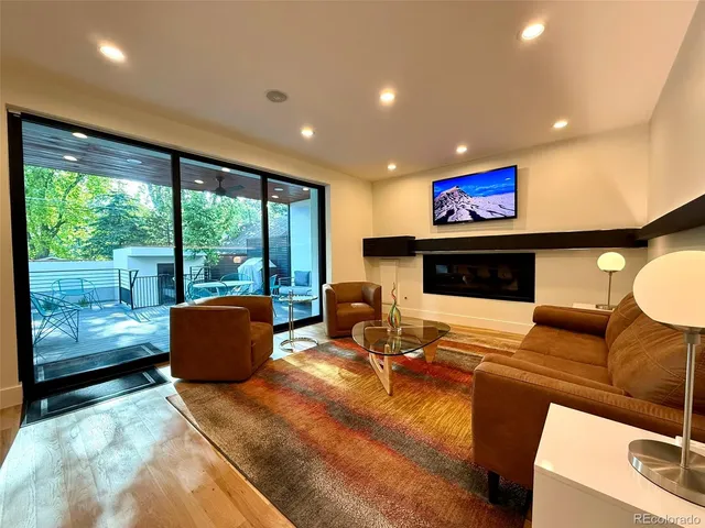 a living room with furniture a flat screen tv and a large window