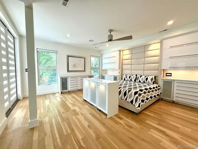 a spacious bedroom with a bed and a dresser