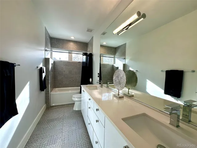 a bathroom with a double vanity sink toilet and shower