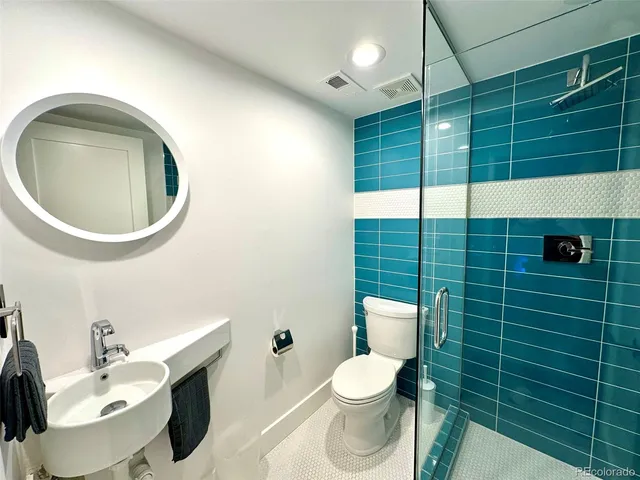 a bathroom with a toilet a sink and mirror