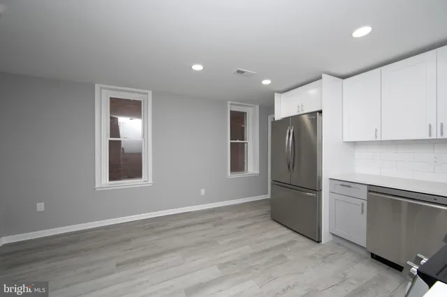 a kitchen with stainless steel appliances granite countertop a refrigerator and a stove top oven