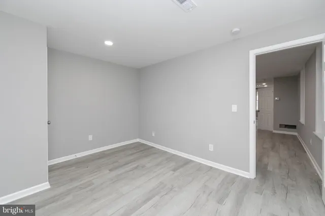 a view of an empty room with wooden floor
