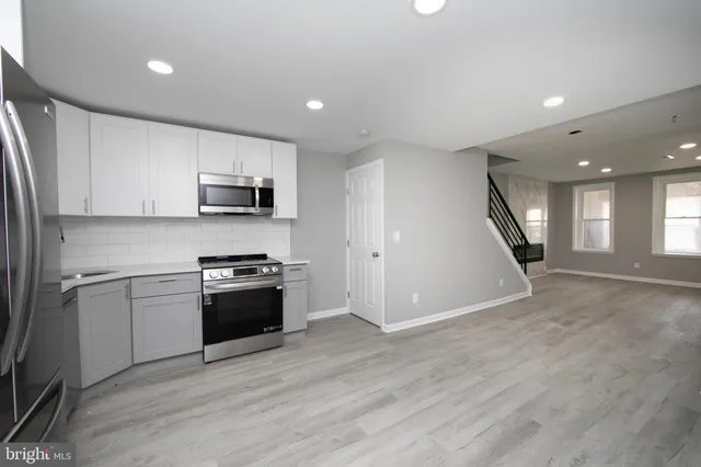 a kitchen with stainless steel appliances granite countertop a stove a sink and a refrigerator