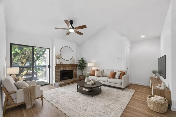 a living room with furniture fireplace and a large window