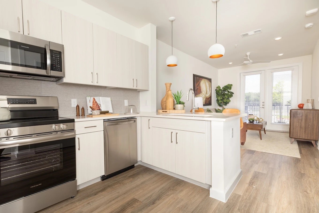 1690 North Loop, Unit 478 Houston, TX 77009 - Photo 4 of 28 a kitchen with white cabinets stainless steel appliances and wooden floor