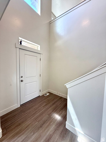 1823 South Longview Road Santaquin, UT 84655 - Photo 4 of 69 Entryway featuring wood-finish flooring, a white paneled door with transom window, high ceilings, and a staircase with white balustrade
