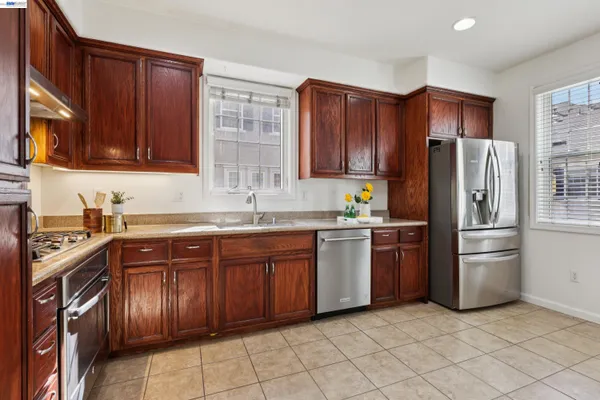 a kitchen with stainless steel appliances granite countertop a refrigerator and a sink