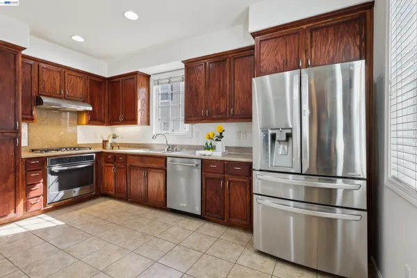 a kitchen with granite countertop stainless steel appliances and wooden cabinets