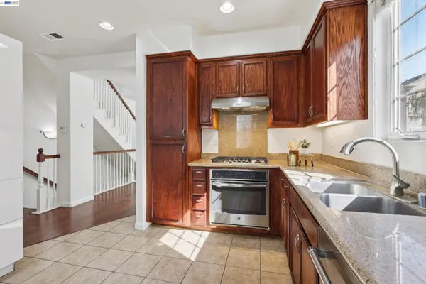 a kitchen with stainless steel appliances granite countertop a stove a sink and a microwave