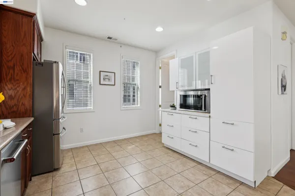 a kitchen with white cabinets stainless steel appliances and a window