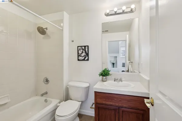 a bathroom with a granite countertop sink toilet a mirror and shower