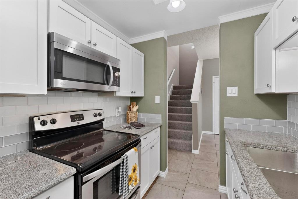 8404 Forest Lane, Unit 1305 Dallas, TX 75243 - Photo 12 of 32 a kitchen with stainless steel appliances granite countertop a stove microwave and cabinets