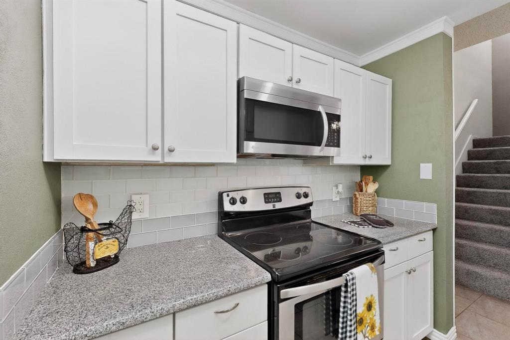 8404 Forest Lane, Unit 1305 Dallas, TX 75243 - Photo 13 of 32 a kitchen with granite countertop a sink a stove and microwave