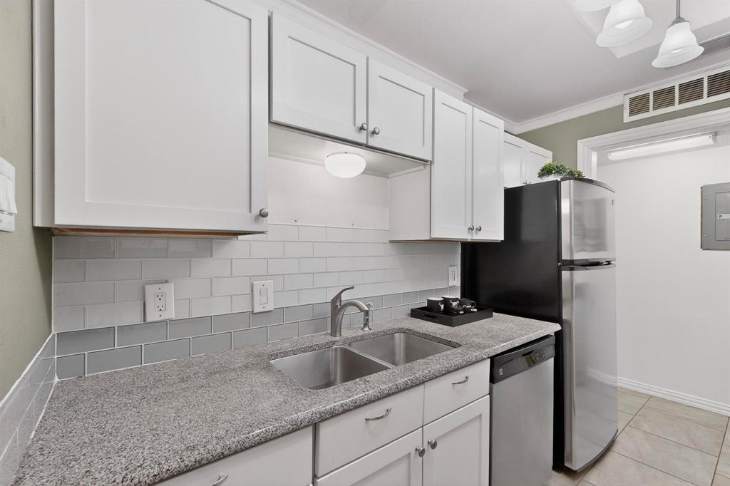 8404 Forest Lane, Unit 1305 Dallas, TX 75243 - Photo 14 of 32 a kitchen with stainless steel appliances granite countertop a sink a refrigerator and a granite counter tops