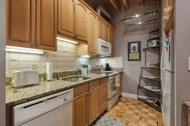 a kitchen with stainless steel appliances granite countertop a sink stove and cabinets