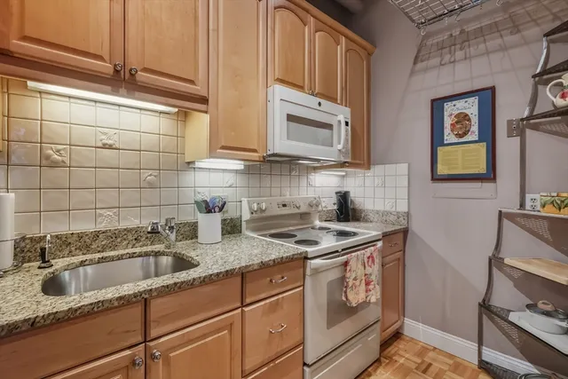 a kitchen with stainless steel appliances granite countertop a sink stove and cabinets