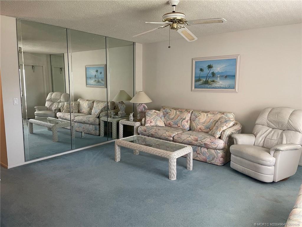 1225 Northwest 21st Street, Unit 353509 Stuart, FL 34994 - Photo 4 of 15 a living room with furniture and a chandelier