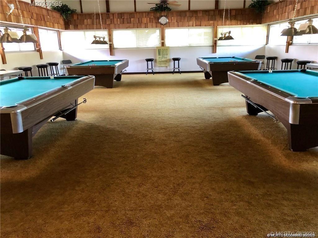 1225 Northwest 21st Street, Unit 353509 Stuart, FL 34994 - Photo 10 of 15 a room with pool table and windows