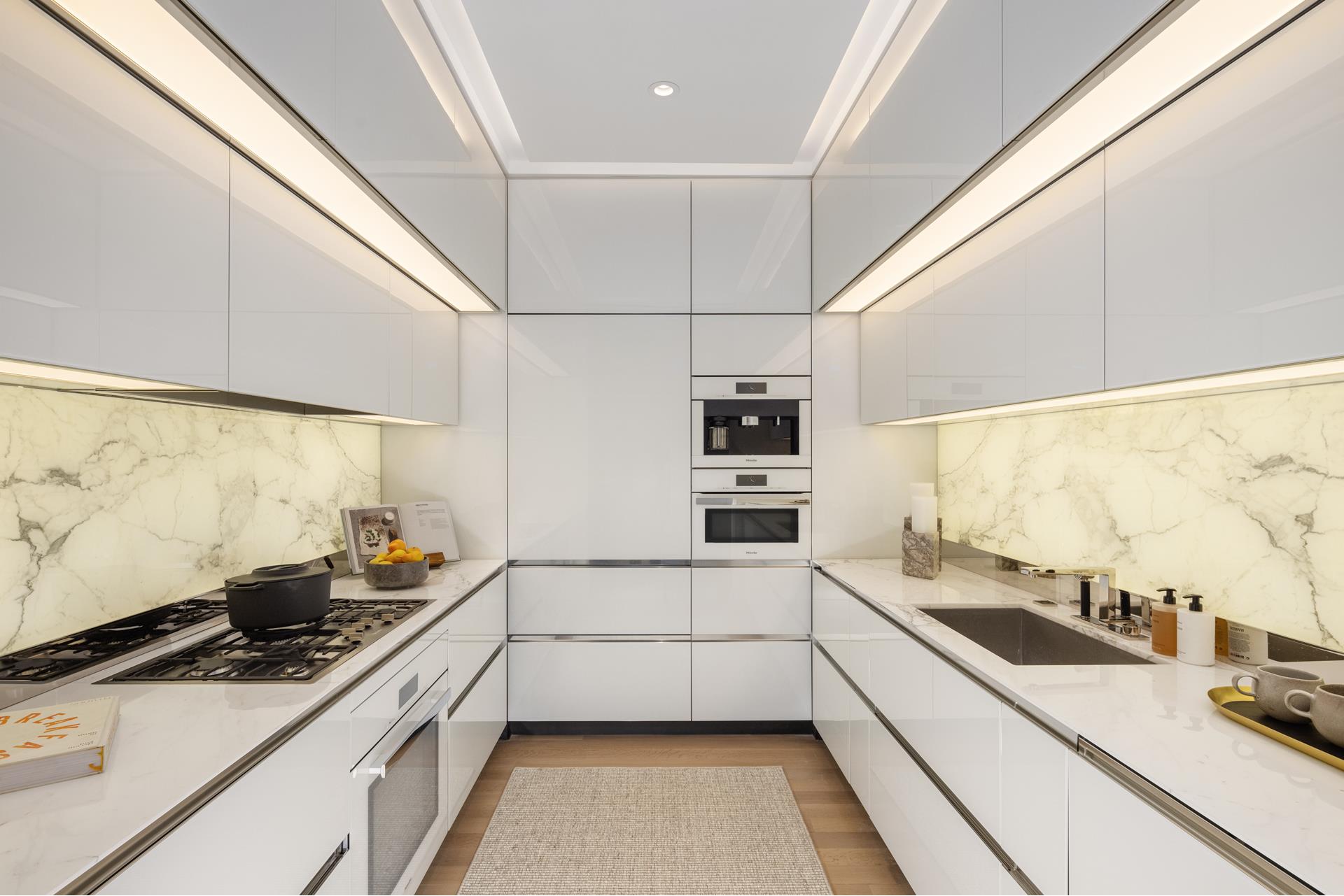 53 West 53rd Street, Unit 34C Manhattan, NY 10019 - Photo 5 of 15 a kitchen with stainless steel appliances a sink stove and cabinets