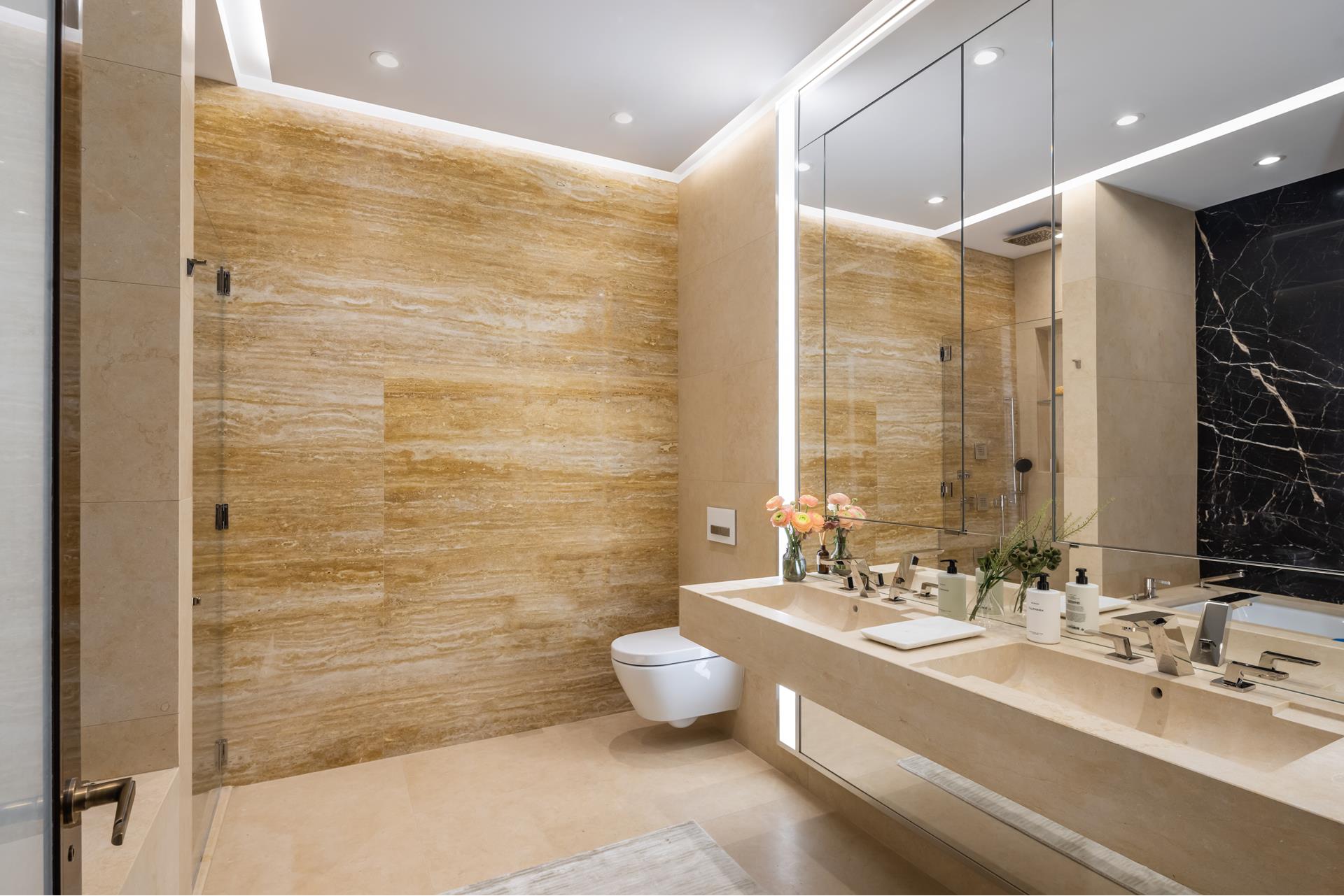 53 West 53rd Street, Unit 34C Manhattan, NY 10019 - Photo 8 of 15 a bathroom with a double vanity sink toilet and a shower