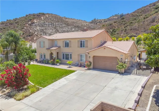a view of a white house next to a yard with big trees