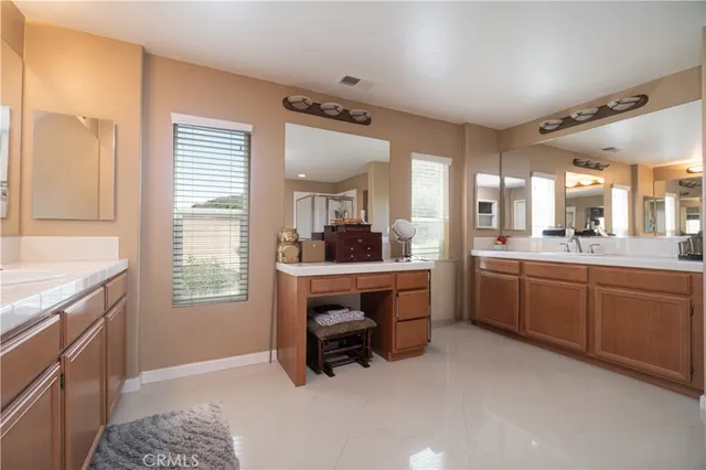 a large bathroom with a window double vanity sink and a mirror