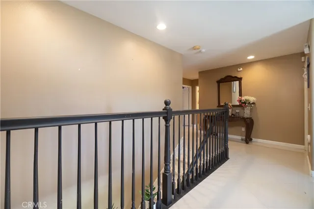 a view of a hallway with wooden floor and a bathroom