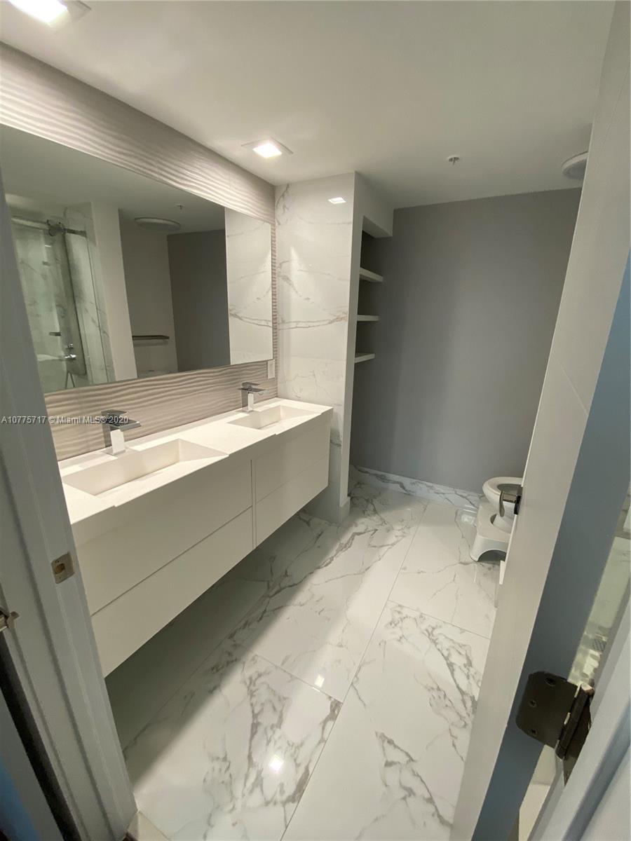 2000 North Bayshore Drive, Unit 407 Miami, FL 33137 - Photo 6 of 19 a bathroom with a bathtub sink and mirror