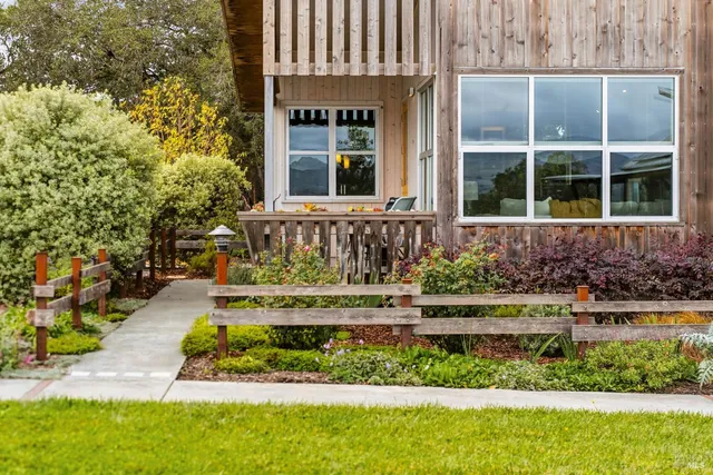 a front view of a house with a yard and potted plants