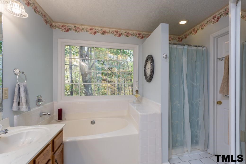 1241 Hillingdon Way Raleigh, NC 27614 - Photo 11 of 21 Master Bath features a double sink vanity, large soaker tub with private, wooded view, standing shower, toilet room, linen closet, and a CEDAR-LINED walk-in closet!