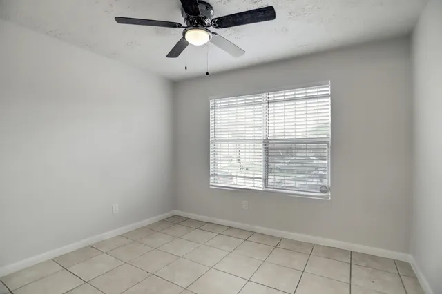 an empty room with a window and a fan