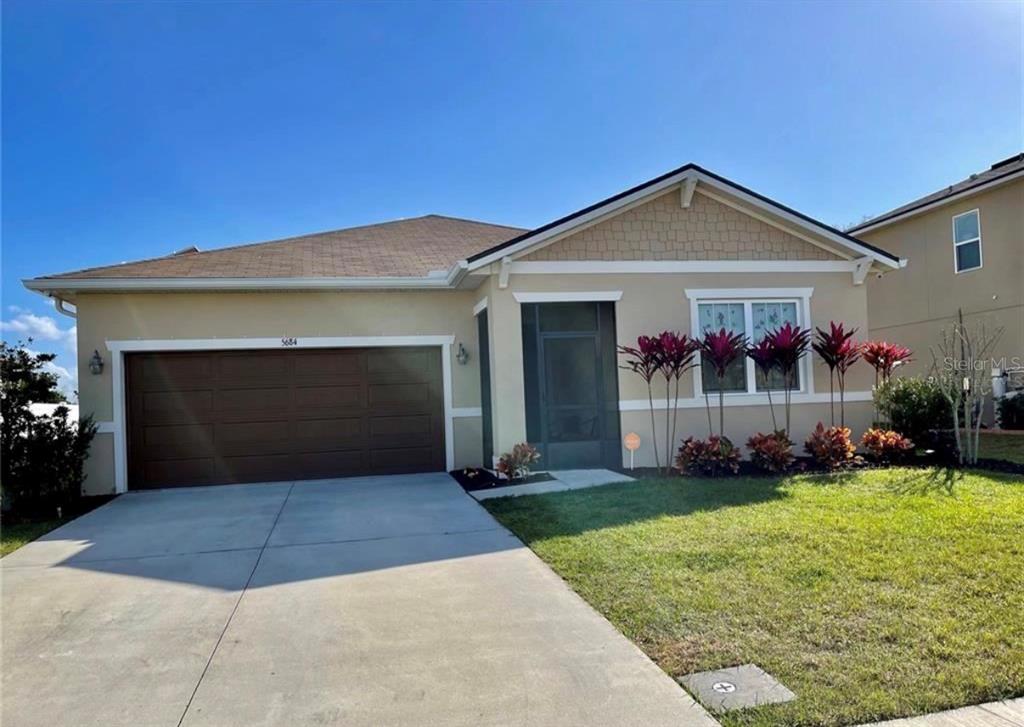 5684 Western Sun Drive St. Cloud, FL 34771 - Photo 1 of 16 a front view of a house with a yard and garage