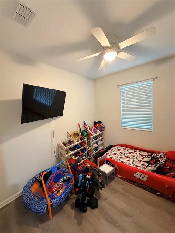 5684 Western Sun Drive St. Cloud, FL 34771 - Photo 11 of 16 a bedroom with furniture and a flat screen tv