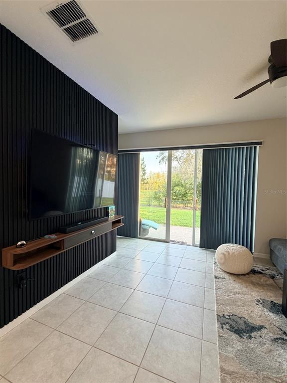 5684 Western Sun Drive St. Cloud, FL 34771 - Photo 4 of 16 a living room with a large window and a flat screen tv